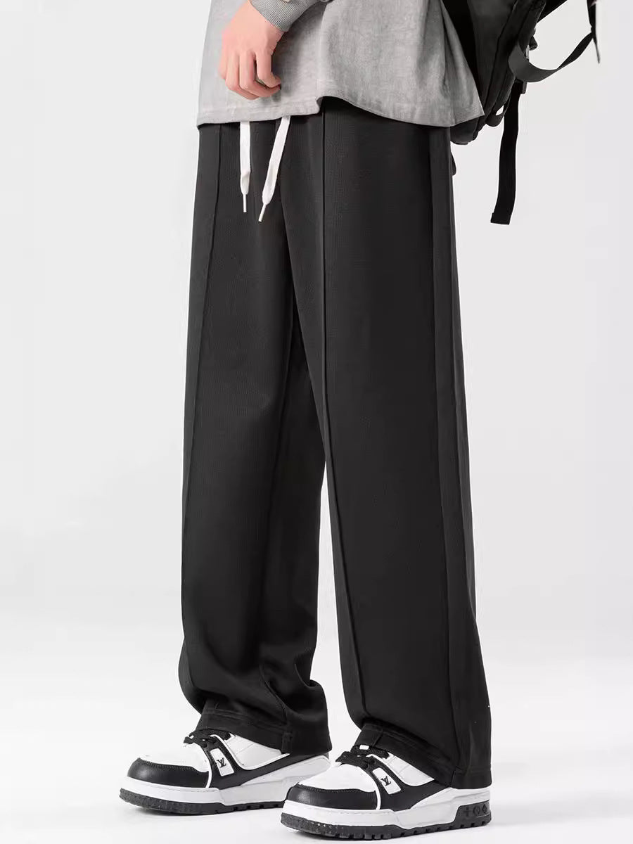 A pair of loose straight casual men's pants in black color, with a focus on the design and fit.