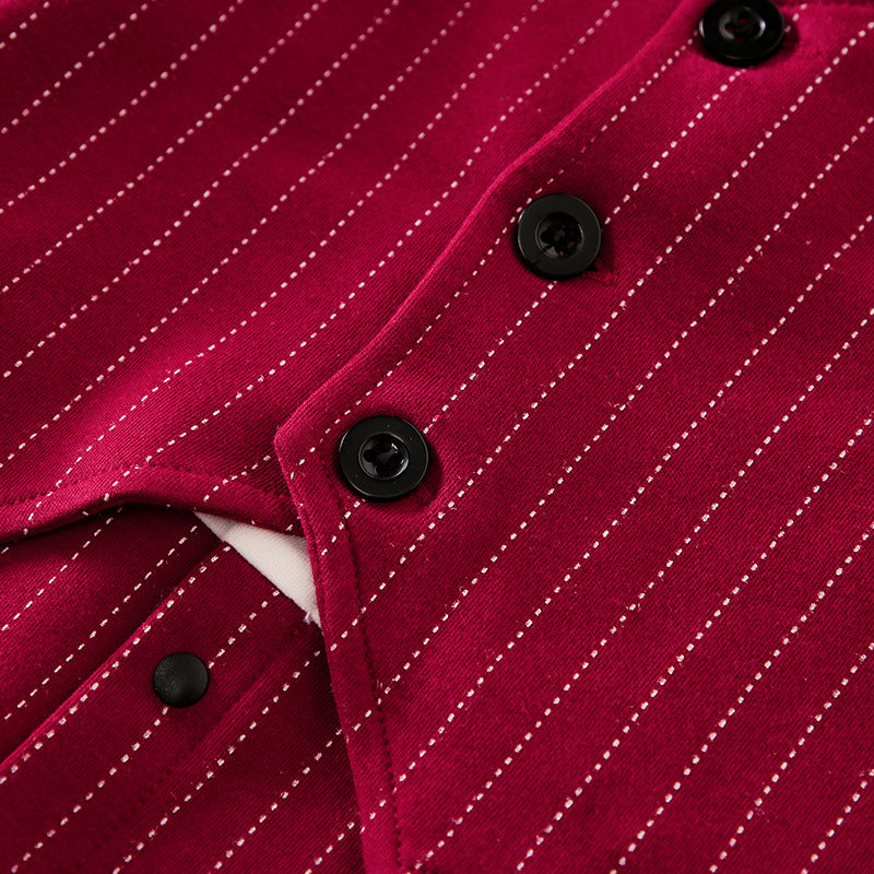 A set of baby autumn clothing featuring a wine red and white striped romper with long sleeves, a white shirt, and a bow tie. Accompanied by white baby shoes and a frame for a photo.