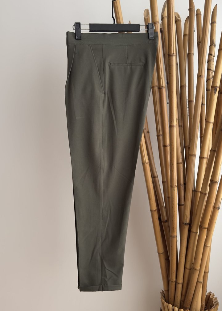 A pair of high-waisted, straight-leg black trousers with a pocket on the back, displayed on a hanger against a neutral background.