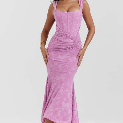 A long, sleeveless, pink evening dress with an off-shoulder neckline and a backless design, featuring a high-waist and suspender skirt.