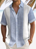 A man wearing a short-sleeved, striped beach shirt in white and blue colors