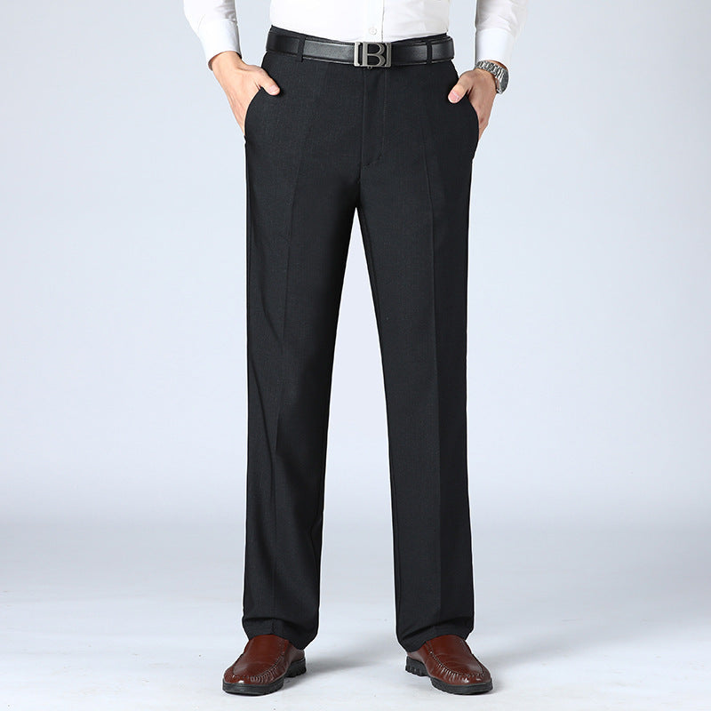 A pair of men's straight-leg suit pants in a light gray color, displayed in a full-length image with a person standing with one hand in a pocket.