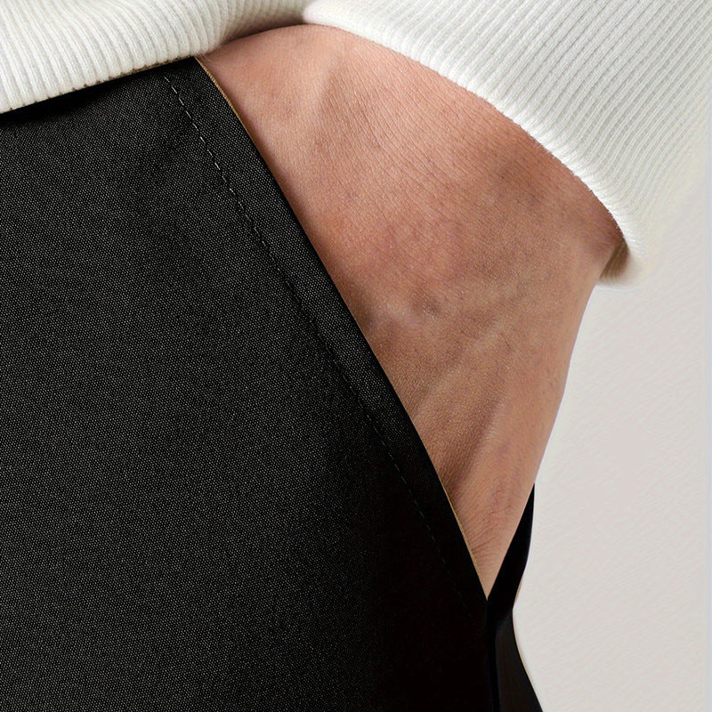 A person wearing black straight-leg ankle-tied overalls casual pants with a mid-waist waist and white sneakers.