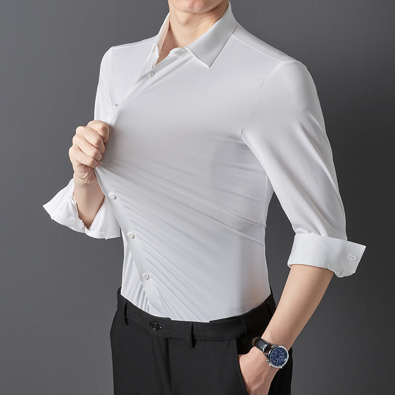 A person in a white long-sleeved shirt rolling up the sleeves, showcasing the shirt's fit and material.