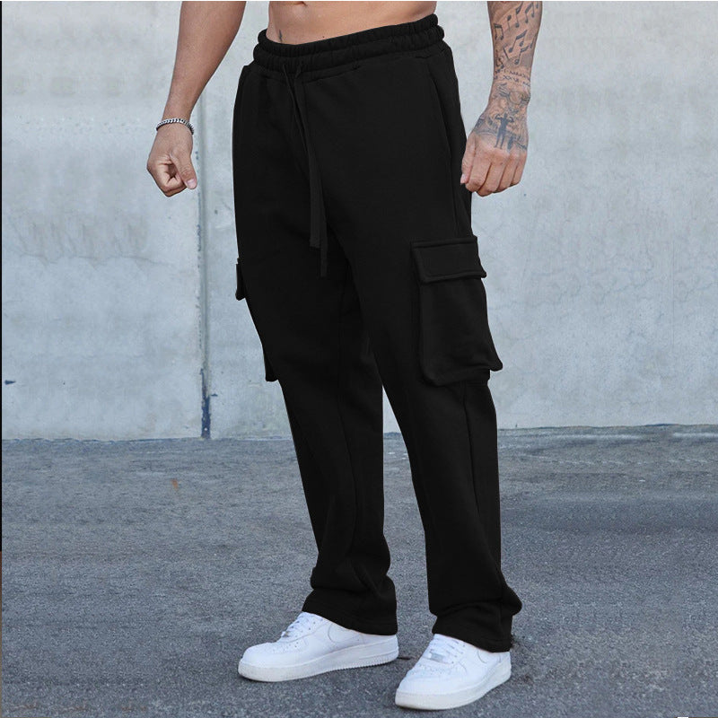 A pair of men's straight-leg trousers with multi-pocket design and drawstring waist in a black color.