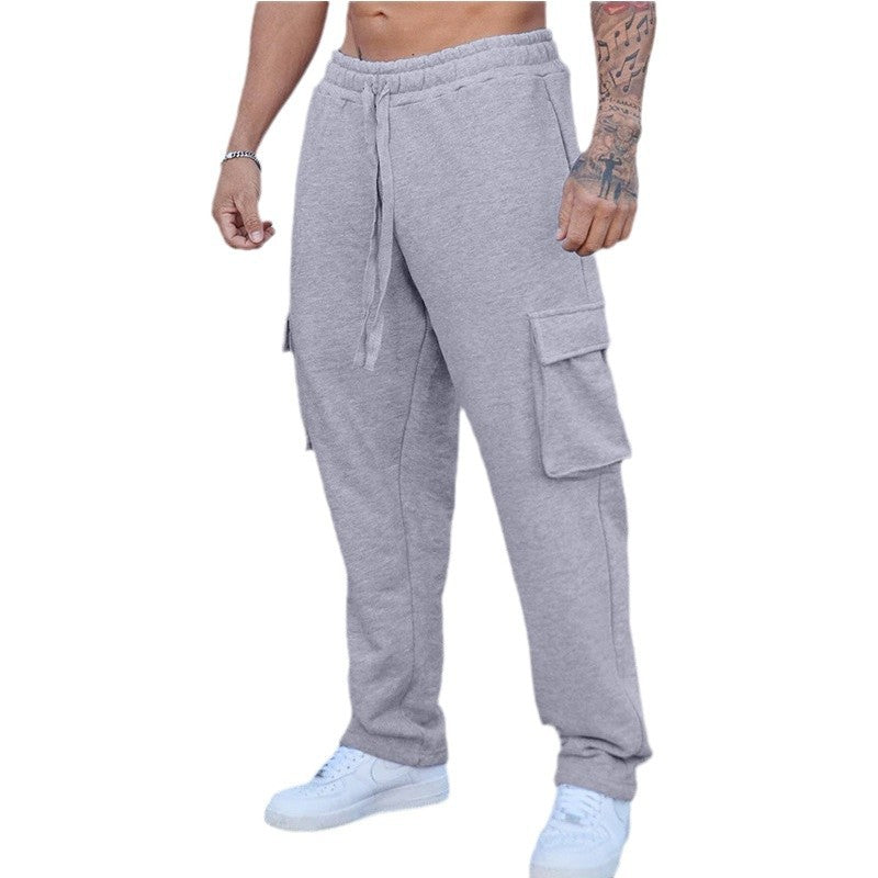 A pair of men's straight-leg trousers with multi-pocket design and drawstring waist in a black color.