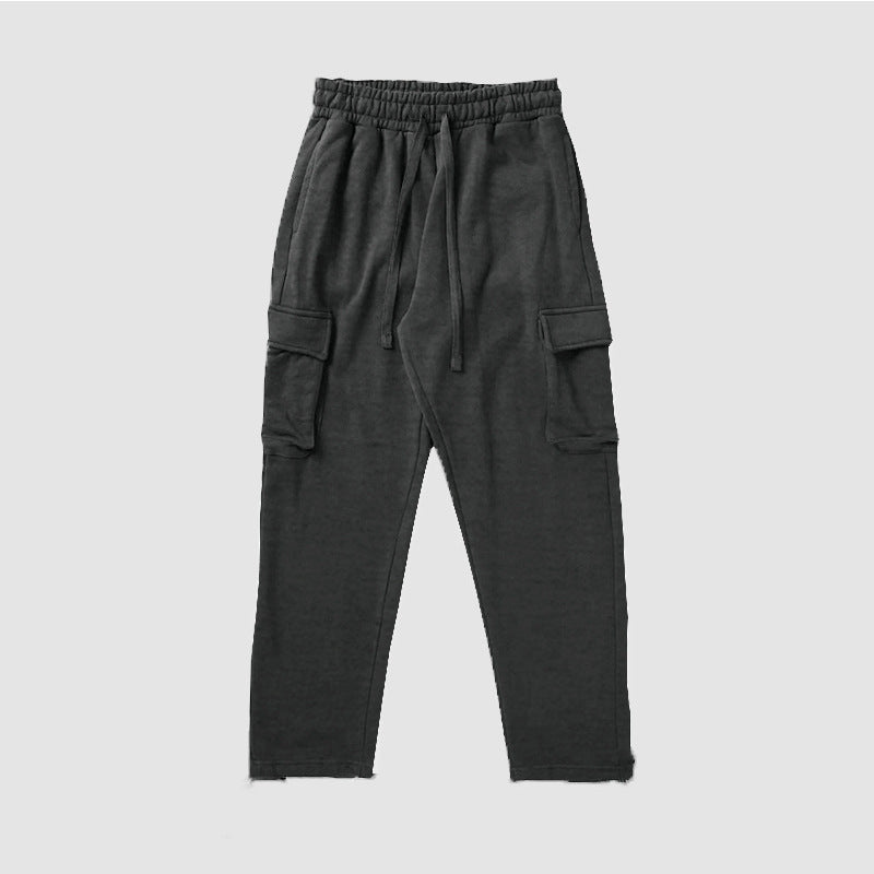 A pair of men's straight-leg trousers with multi-pocket design and drawstring waist in a black color.