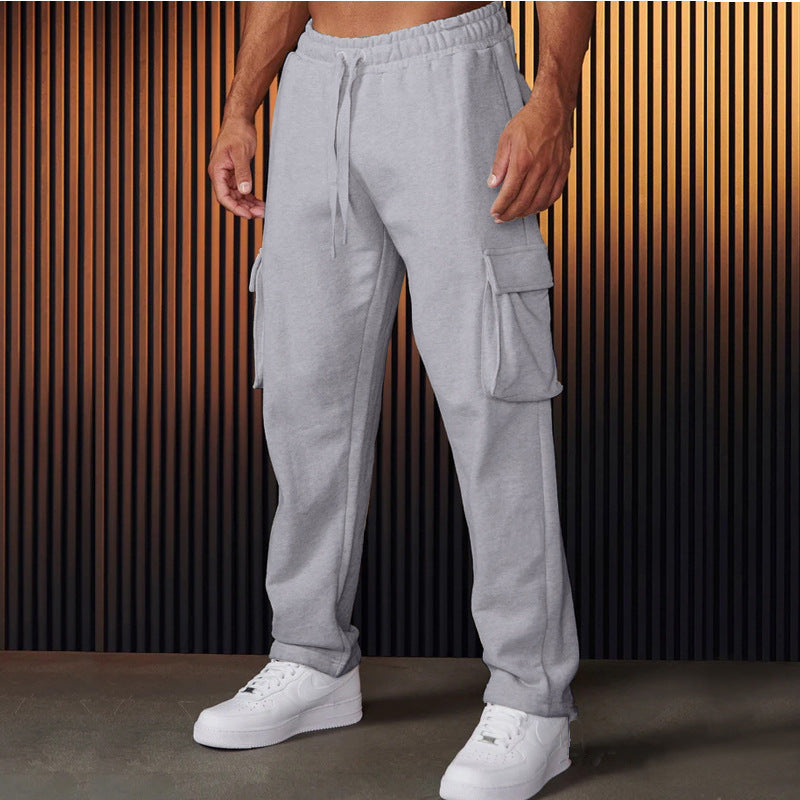 A pair of men's straight-leg trousers with multi-pocket design and drawstring waist in a black color.