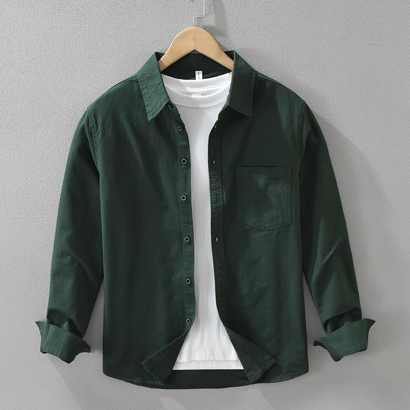 A long sleeve men's shirt in dark green color, displayed on a wooden hanger with a white inner shirt visible.