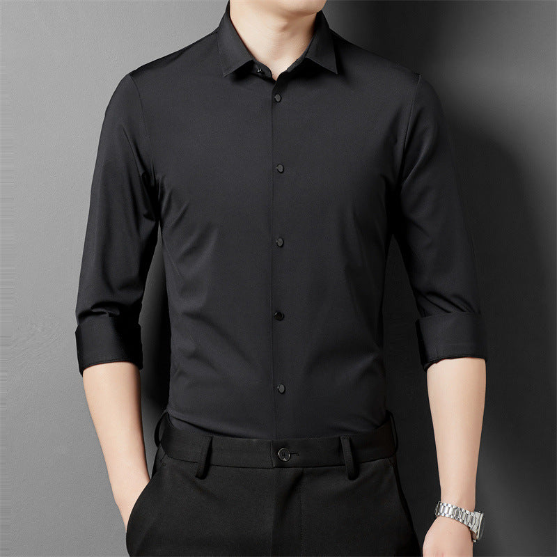 A person in a black long-sleeved shirt rolling up the sleeves, showcasing the shirt's fit and material.