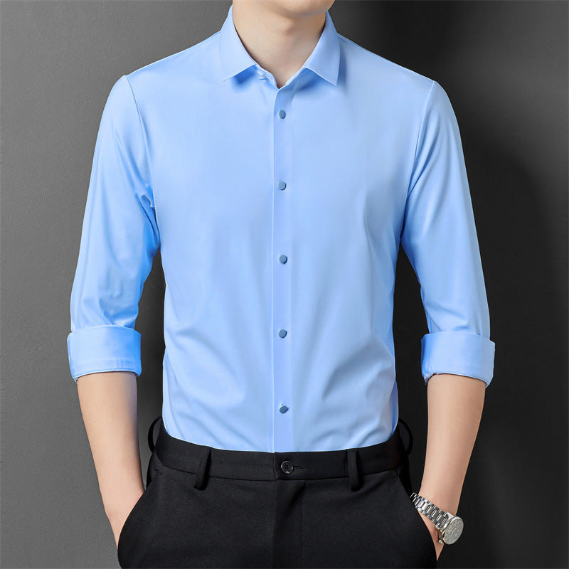 A person in a blue long-sleeved shirt rolling up the sleeves, showcasing the shirt's fit and material.