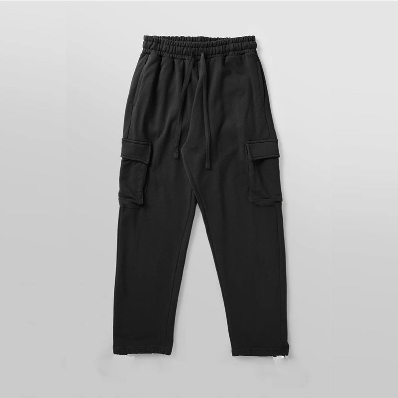 A pair of men's straight-leg trousers with multi-pocket design and drawstring waist in a black color.