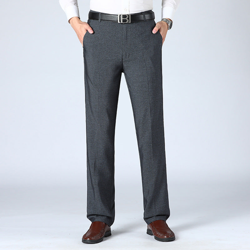 A pair of men's straight-leg suit pants in a light gray color, displayed in a full-length image with a person standing with one hand in a pocket.