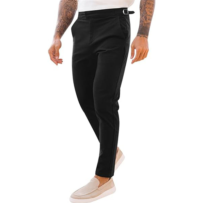 A pair of men's slim fit casual mid waist pencil pants in black color, featuring a zipper fly and a belt loop at the waist.