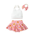 A set of children's clothing including a white sleeveless top with a bow at the neck, a pink skort with a floral pattern, and a matching hairband, displayed against a beige background with decorative elements like flowers and stars.