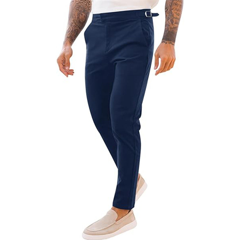 A pair of men's slim fit casual mid waist pencil pants in black color, featuring a zipper fly and a belt loop at the waist.