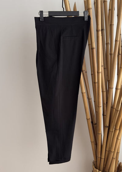 A pair of high-waisted, straight-leg black trousers with a pocket on the back, displayed on a hanger against a neutral background.