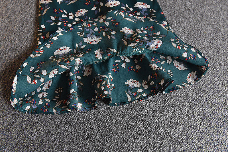 A girls' short-sleeved t-shirt and suspender skirt two-piece suit displayed on a mannequin, with the skirt in a dark green floral pattern and the t-shirt in white.