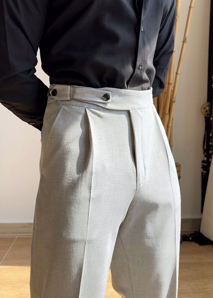 A pair of high-waisted, straight-leg black trousers with a pocket on the back, displayed on a hanger against a neutral background.